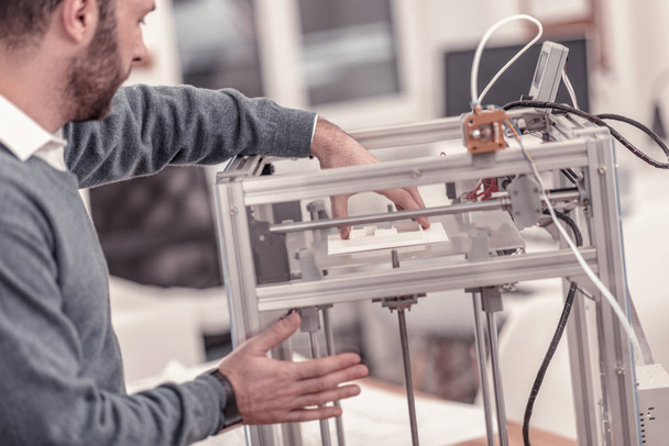 Ingenious designer working with 3D printer in design studio - Foto, afbeelding