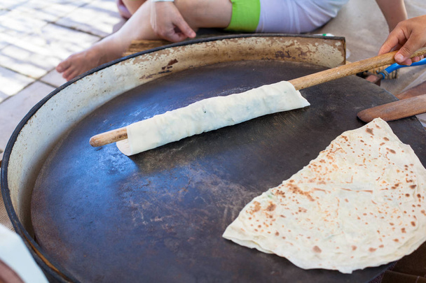 Pita chléb s tvarohem a zelení. Příprava tradiční chléb na pouliční trh. - Fotografie, Obrázek