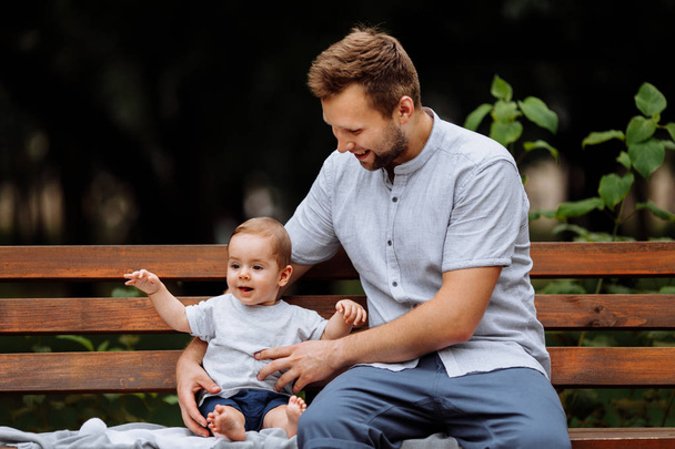 Szczęśliwy młody ojciec z synem w parku - Zdjęcie, obraz