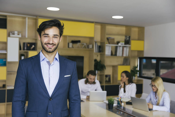 Confident young business man standing in the office - 写真・画像
