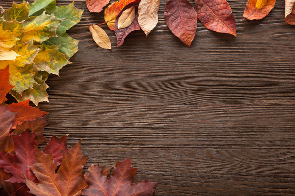 vista superior de hojas de otoño de colores en el suelo de madera
  - Foto, imagen