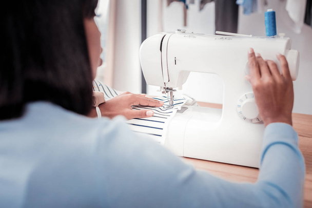 Modern sewing machine being used by skilled tailor - Фото, зображення
