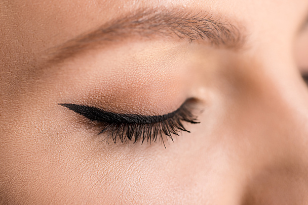 partial view of woman with black eyeliner on eyelid - Foto, immagini