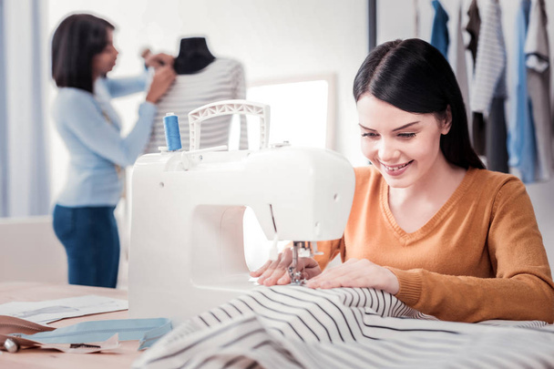 Selective focus of talented designer sewing fashionable clothes - Foto, imagen