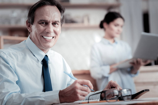 Веселый бизнесмен улыбается во время работы
 - Фото, изображение