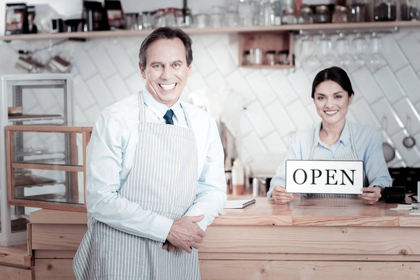 Smiling waitress standing with her colleague with a sign open - Foto, immagini