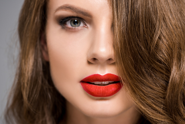portrait of attractive young woman with red lipstick on lips looking at camera - 写真・画像
