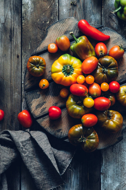 Fresh tomatoes and peppers on rustic wooden background. Flat lay, top view. - Photo, Image