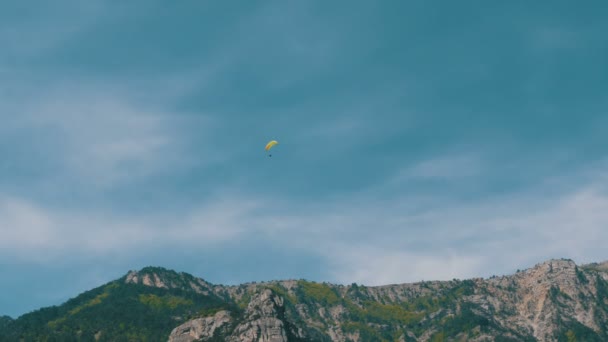 Silhouet van gele paraglider vliegen tegen de hemel - Video