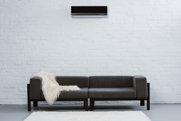 climatiseur suspendu au mur de briques blanches au salon
 - Photo, image