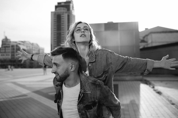 young adult couple fooling around on city street, black and white - Fotoğraf, Görsel