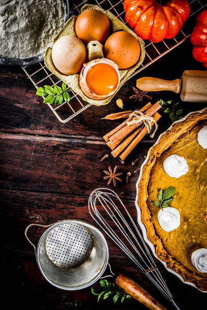 Autumn baking background, baking ingredients for pies, cookies - pumpkins, pumpkin pie, spices, flour, eggs, rolling pin, whisk, old wooden table top view copy space, with notebook for recipes - 写真・画像