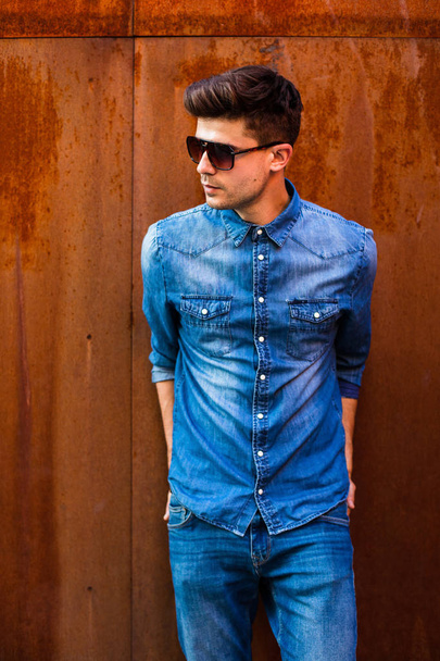 handsome and sexy man. young guy in jeans outfit with sunglasses looking to side, very confident, fashion concept - Foto, immagini