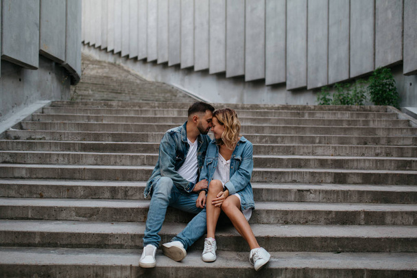 young adult couple in casual clothing on concrete steps - Φωτογραφία, εικόνα