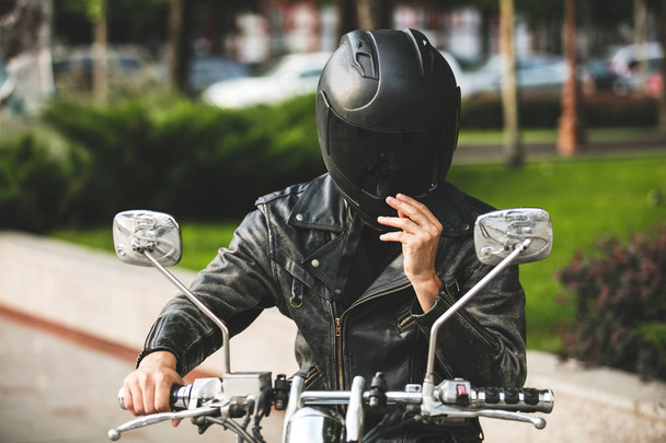young and cool. motorcyclist on his bike and with helmet on his head riding motorcycle - Foto, immagini