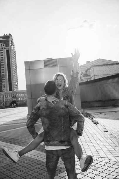 young adult couple fooling around on city street, black and white - Fotoğraf, Görsel