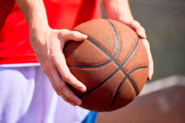 Close view of man holding basketball in hands - 写真・画像