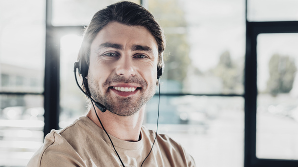 Close-up πορτρέτο της χαμογελαστός νεαρός υποστήριξη hotline εργαζόμενος με ακουστικά - Φωτογραφία, εικόνα