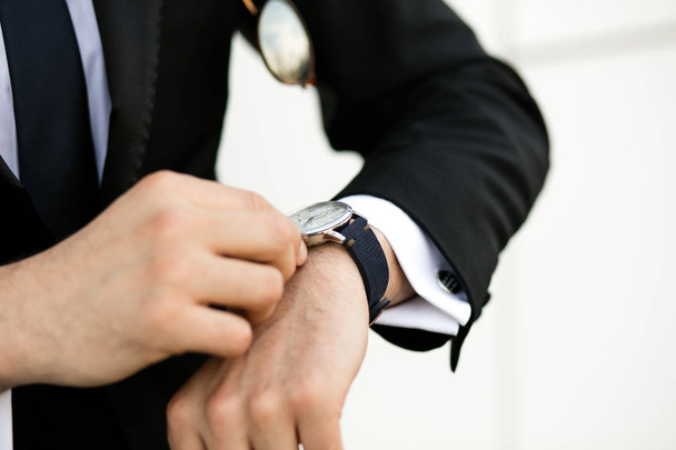 manos de un hombre de negocios ajustando su reloj de mano
 - Foto, Imagen