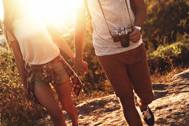 cropped image of couple in casual clothing holding hands while walking outdoors - Foto, Bild