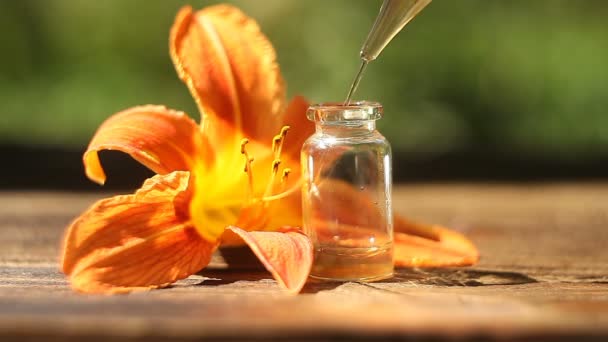 Essence of flowers on table in beautiful glass jar - Video