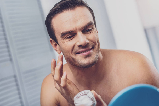 Man with bristle face using face cream - Fotoğraf, Görsel