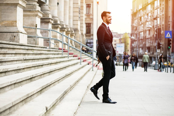 κομψή κομψό άνδρα με γυαλιά ηλίου, επιτυχημένος επιχειρηματίας, το περπάτημα στο δρόμο έξω από το - Φωτογραφία, εικόνα