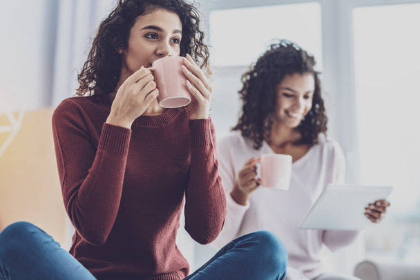 Positive delighted woman girls drinking tea - 写真・画像