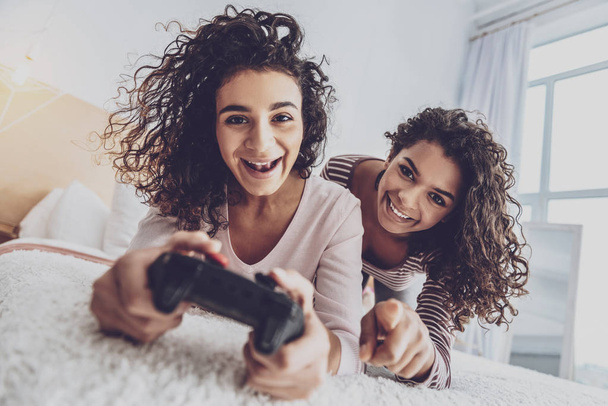 Joyful young females playing computer games - 写真・画像