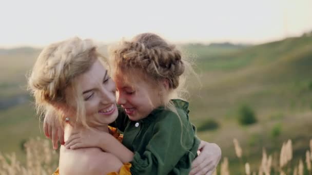 Mãe com sua filha em seus braços ao ar livre
 - Filmagem, Vídeo