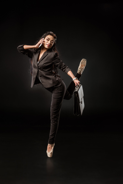 Stylový podnikatelka v formální oblečení a baletní boty na smartphone na černém pozadí - Fotografie, Obrázek