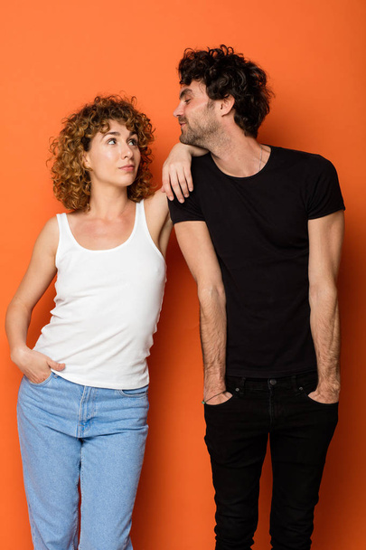 funny young couple on orange background - Foto, Imagen