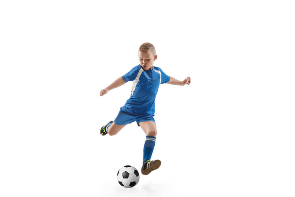 Мальчик с футбольным мячом делает удар ногой
 - Фото, изображение