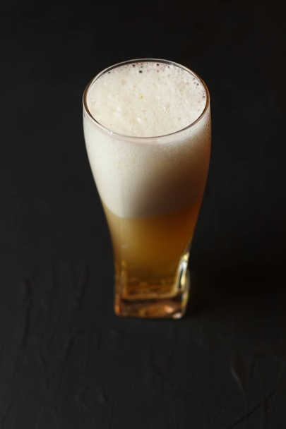 Light beer in a glass bowl on a black background. Beer in the bar. - Photo, image
