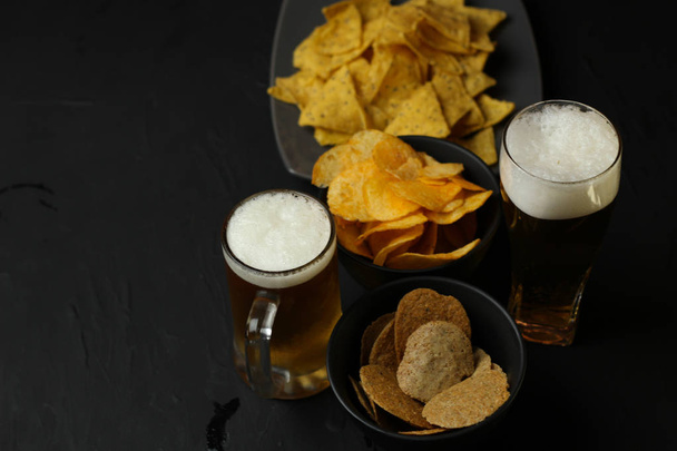 Light beer in a glass bowl on a black background.Beer in the bar and snacks, chips, nuts. - Fotografie, Obrázek