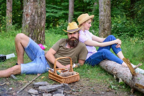 Family relaxing near bonfire after day of mushroom hunting. Family traditions. Couple relaxing after gathering mushrooms in wild for food. Family activity for summer vacation in forest and nature - Фото, изображение
