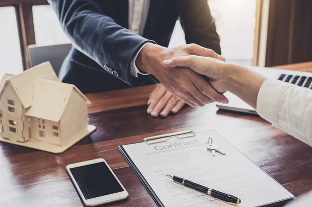 Real estate agent and customers shaking hands together celebrating finished contract after about home insurance and investment loan, handshake and successful deal. - Foto, Bild