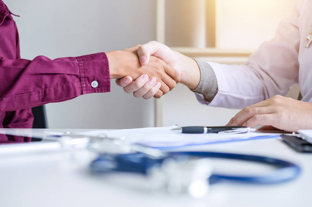 Professional Male doctor in white coat shaking hand with female patient after successful recommend treatment methods, Medicine and health care concept. - Foto, Bild