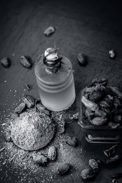 Close up view of oil of Black cardamom with its powder and raw whole black cardamom. - 写真・画像
