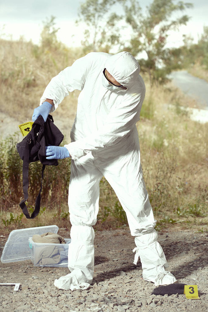 Criminologist technician in DNA free protective suit collecting evidences of probable criminal act - Valokuva, kuva