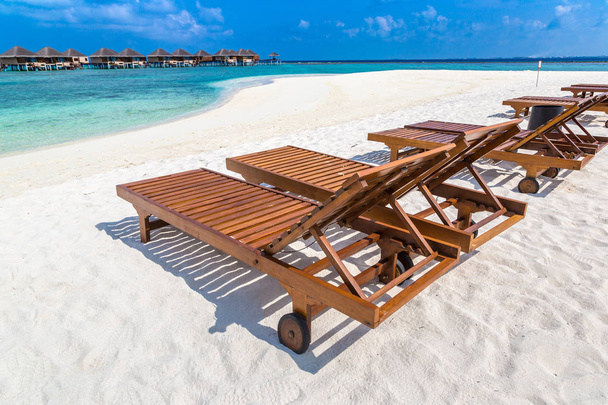 MALDIVAS - 24 DE JUNIO DE 2018: Tumbonas de madera en la playa tropical de las Maldivas en el día de verano
 - Foto, imagen