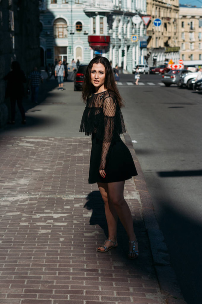 beautiful brunette whirls on a street in the middle of the city, laughs, smiles, happiness, fun - Foto, immagini