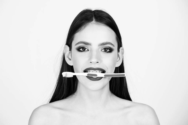 girl with teeth braces and brush, has fashionable makeup - Φωτογραφία, εικόνα