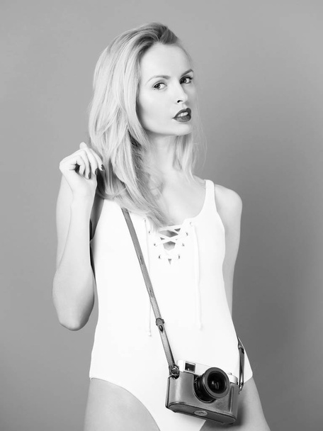 Cute girl photographer with retro camera in white bodysuit - Zdjęcie, obraz