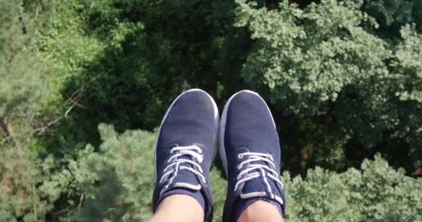 Vista aérea POV. Voando sobre as belas árvores da floresta. Câmera aérea tiro e pernas humanas com tênis azul no quadro. Panorama da paisagem
 - Filmagem, Vídeo