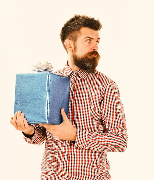 Macho with wrapped blue gift and white bow. - Zdjęcie, obraz