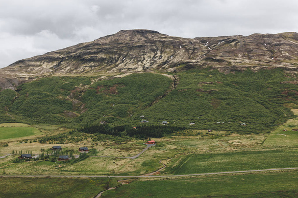 aerial view of landscape with houses and mountains range in Iceland  - Фото, изображение