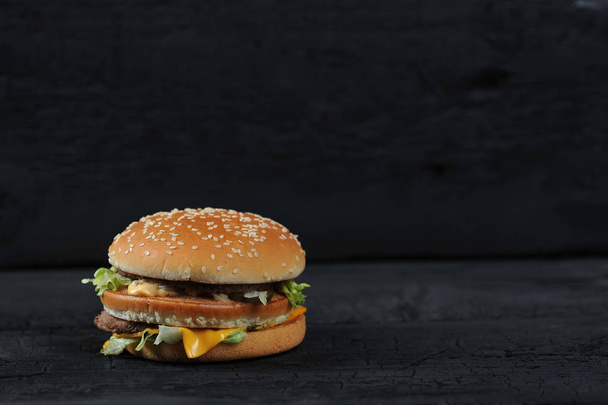 fresh tasty burger on black charcoal background - Foto, Imagem