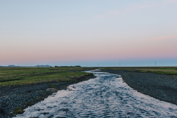 мальовничий вид на ландшафт з річка, що протікає поблизу луг в Ісландії - Фото, зображення