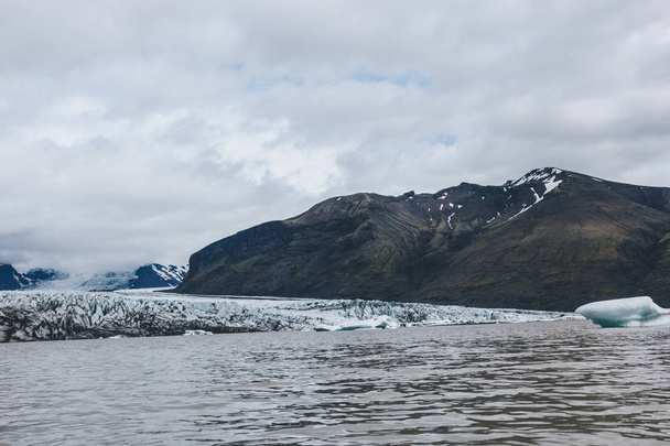 krajina s ledovci Skaftafellsjkull a zasněžené hory proti zatažené obloze v národním parku Skaftafell na Islandu  - Fotografie, Obrázek